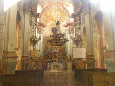 Widok na wnętrze kościoła. Ściany pokryte pięknymi malowidłami dekoracyjnymi. W wykończeniach wnętrza przewaga złota.
